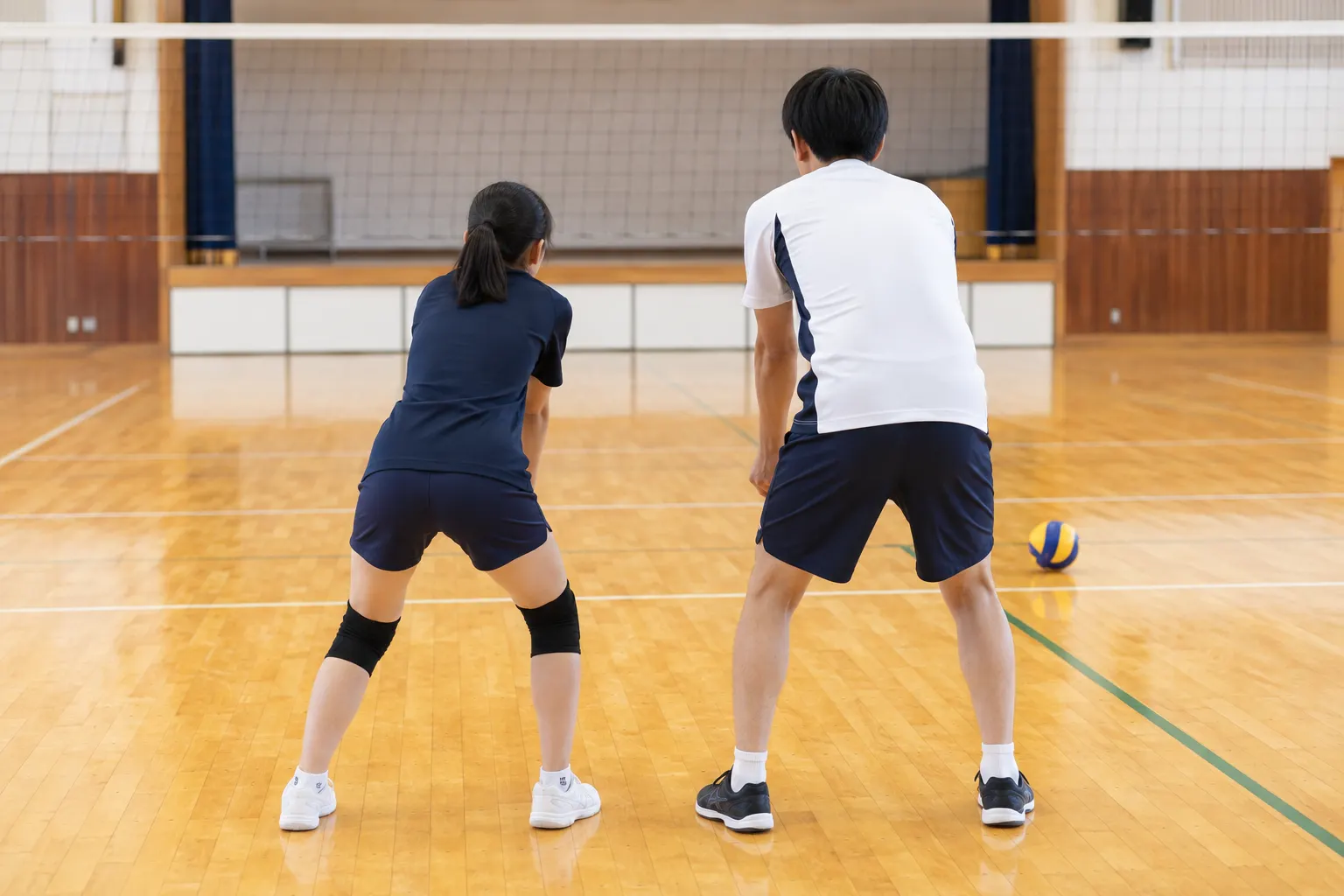 選手と並んで構えを確認するコーチ